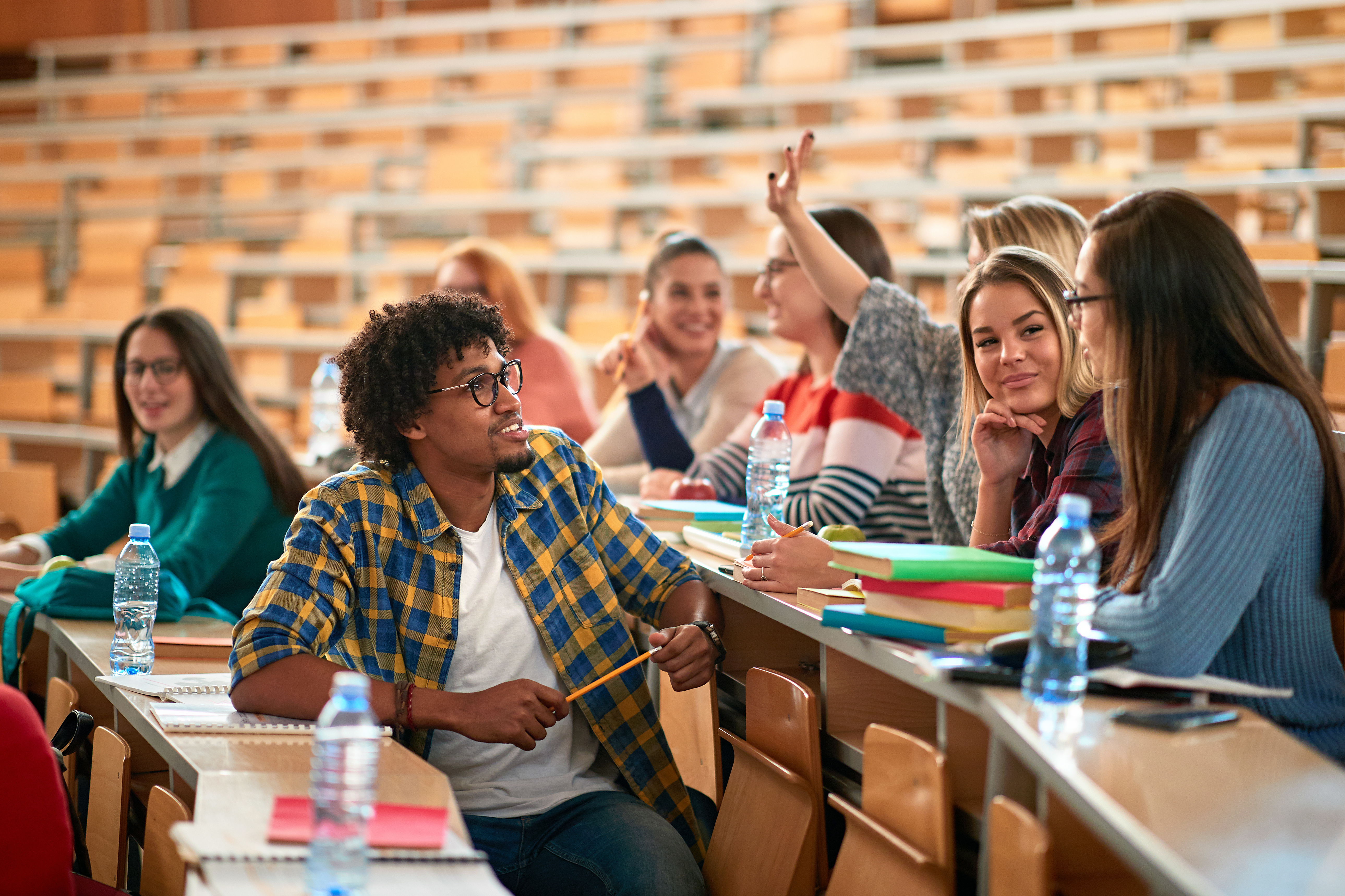 a group of students chatting in a lecture theatre