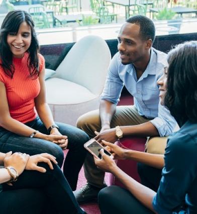 Four students sitting in a break-out area discussing their ideas