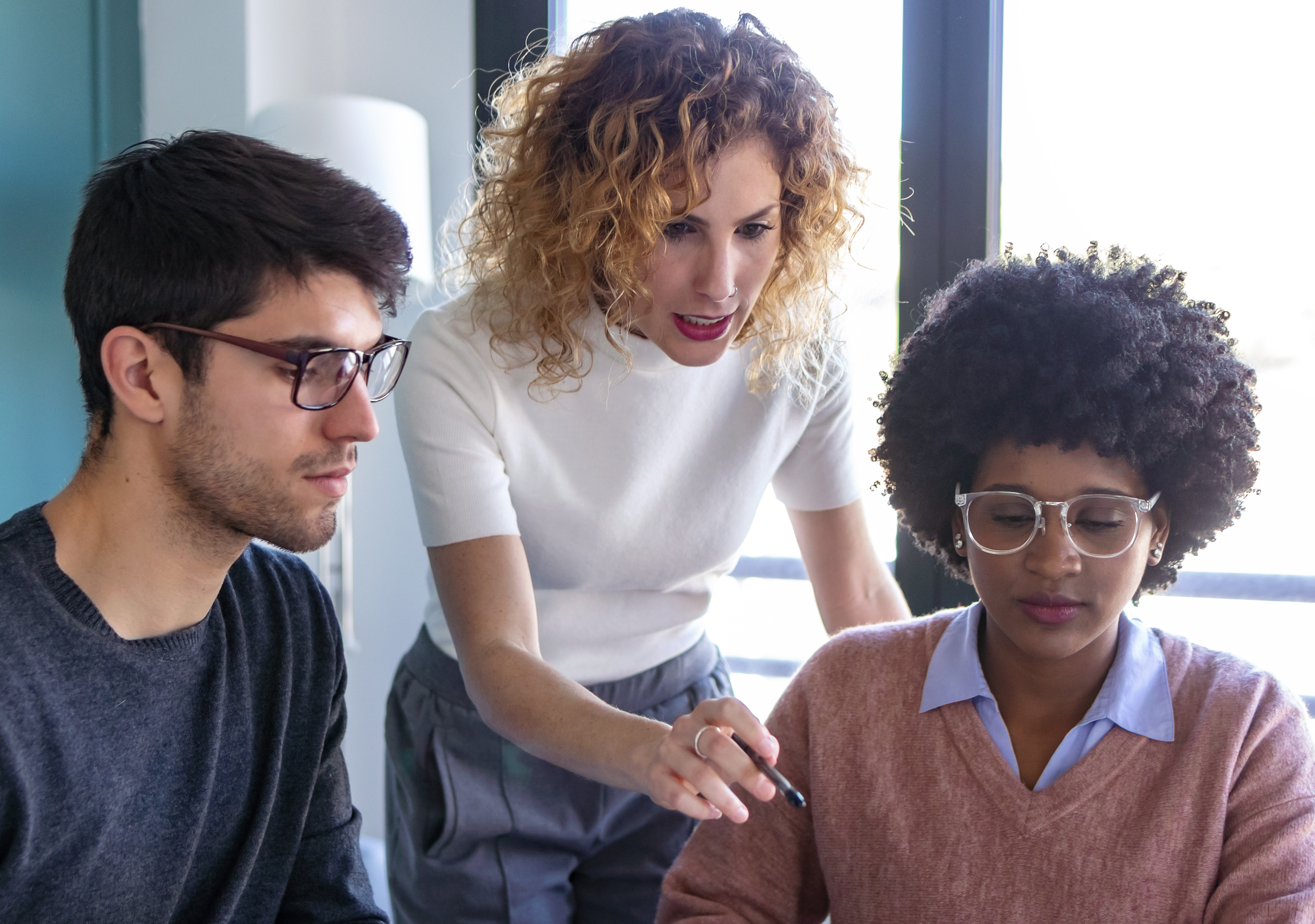 Three young people around laptop