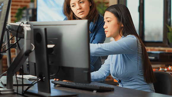 Two women looking at computer screen